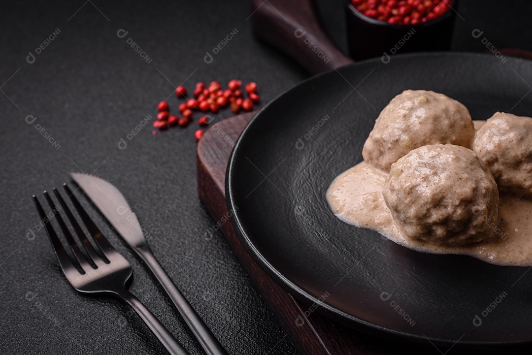 Deliciosas almôndegas de frango ou peru picado com molho de creme de leite com sal e especiarias num prato de cerâmica