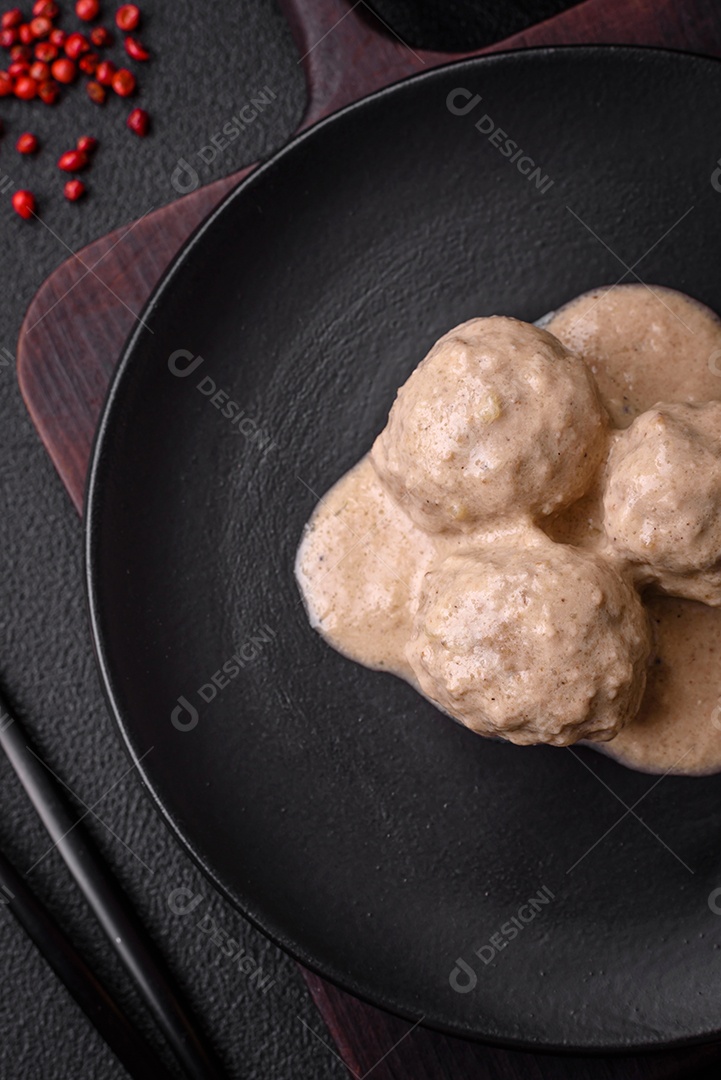 Deliciosas almôndegas de frango ou peru picado com molho de creme de leite com sal e especiarias num prato de cerâmica