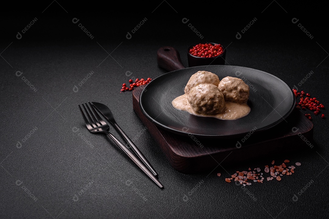 Deliciosas almôndegas de frango ou peru picado com molho de creme de leite com sal e especiarias num prato de cerâmica