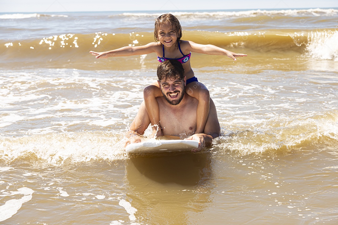 Pai ao lado de sua filha curtindo verão sobre uma praia
