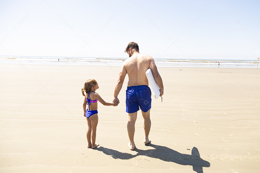 Pai ao lado de sua filha curtindo verão sobre uma praia
