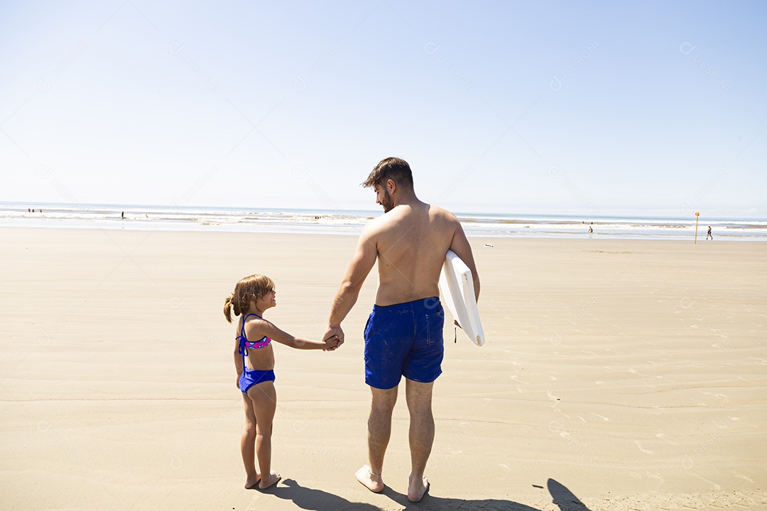 Pai ao lado de sua filha curtindo verão sobre uma praia