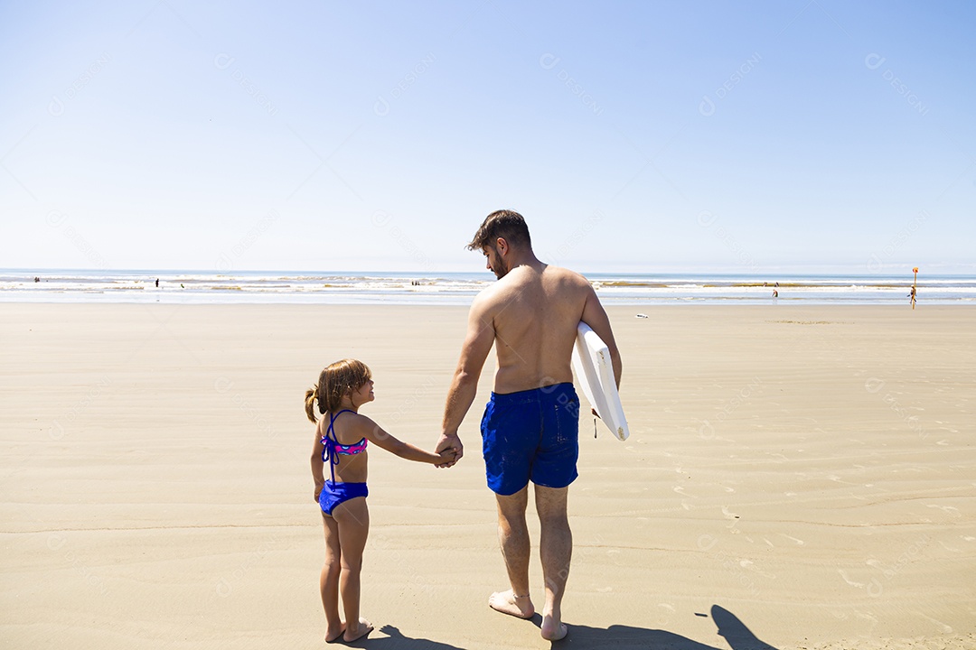 Pai ao lado de sua filha curtindo verão sobre uma praia