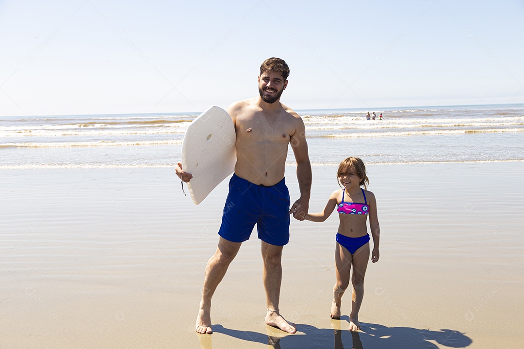 Pai ao lado de sua filha curtindo verão sobre uma praia
