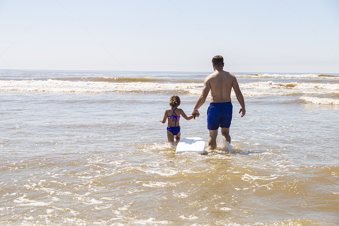 Pai ao lado de sua filha curtindo verão sobre uma praia