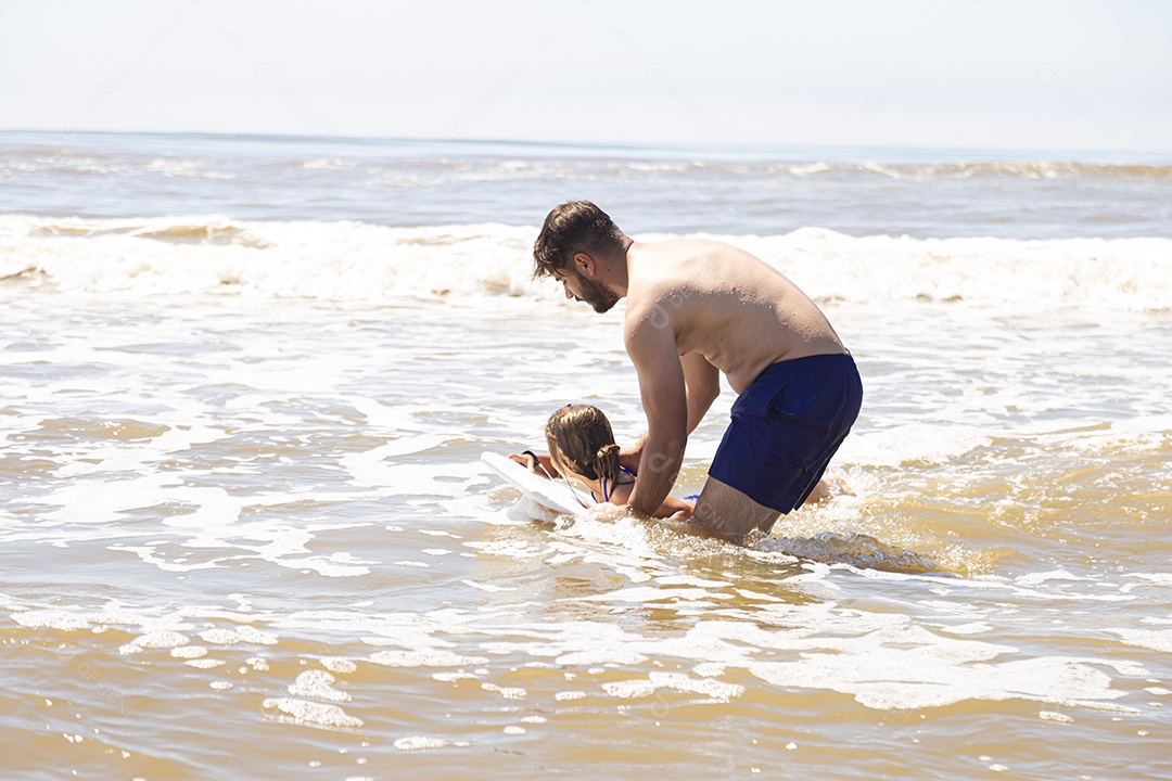 Pai ao lado de sua filha curtindo verão sobre uma praia