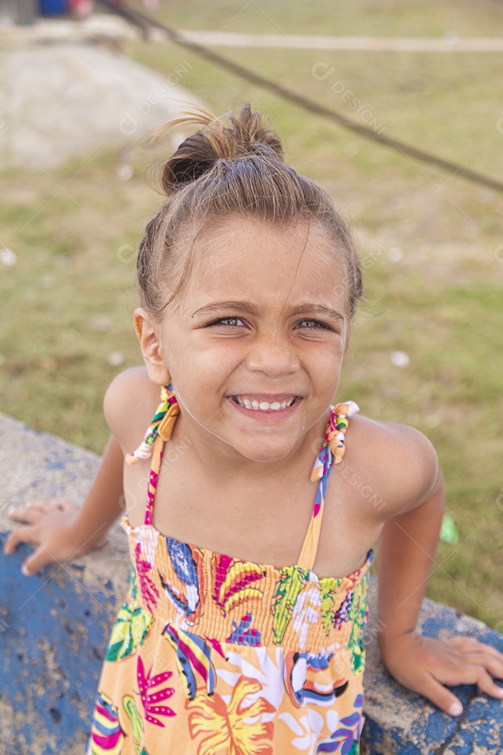 Linda garotinha sorridente sobre campo