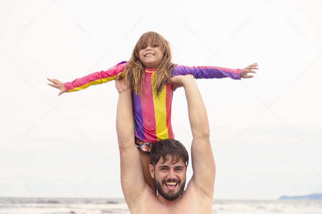 Pai ao lado de sua filha curtindo verão sobre uma praia