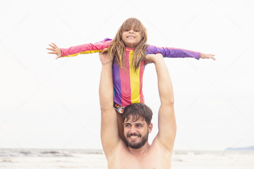Pai ao lado de sua filha curtindo verão sobre uma praia