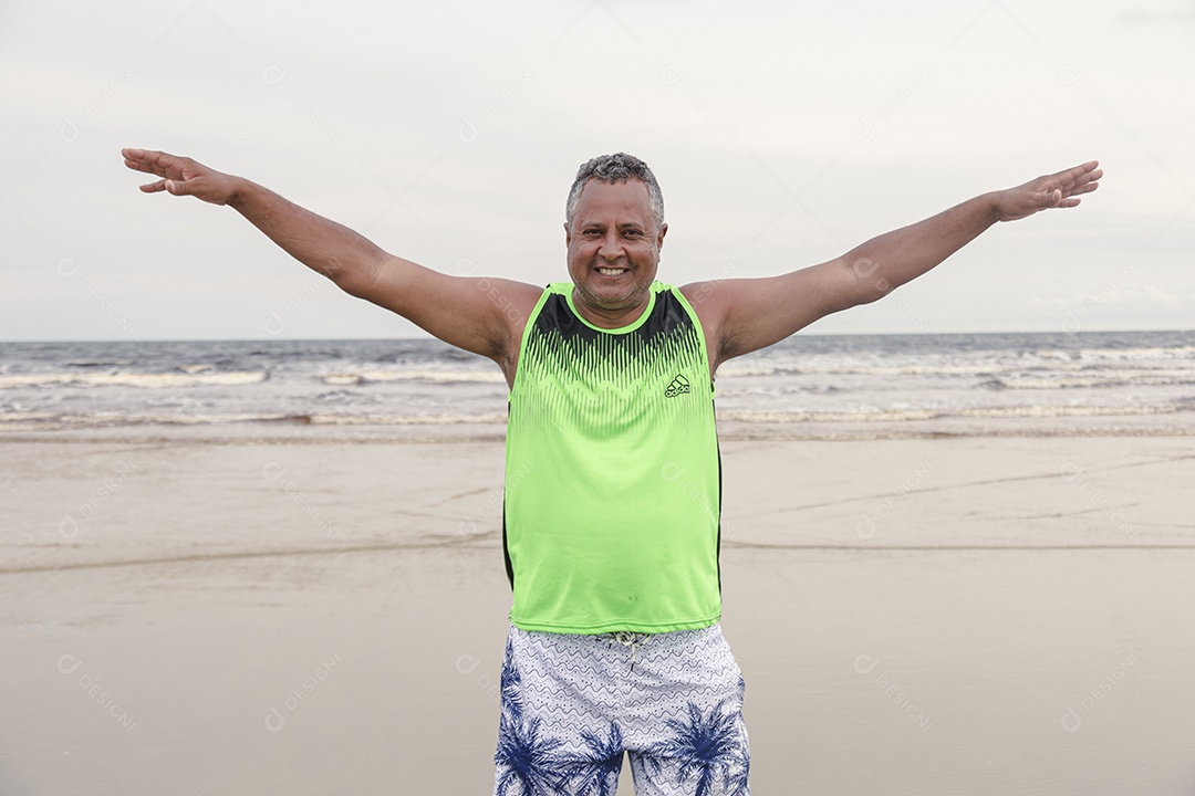 Homem de meia idade feliz sobre uma praia