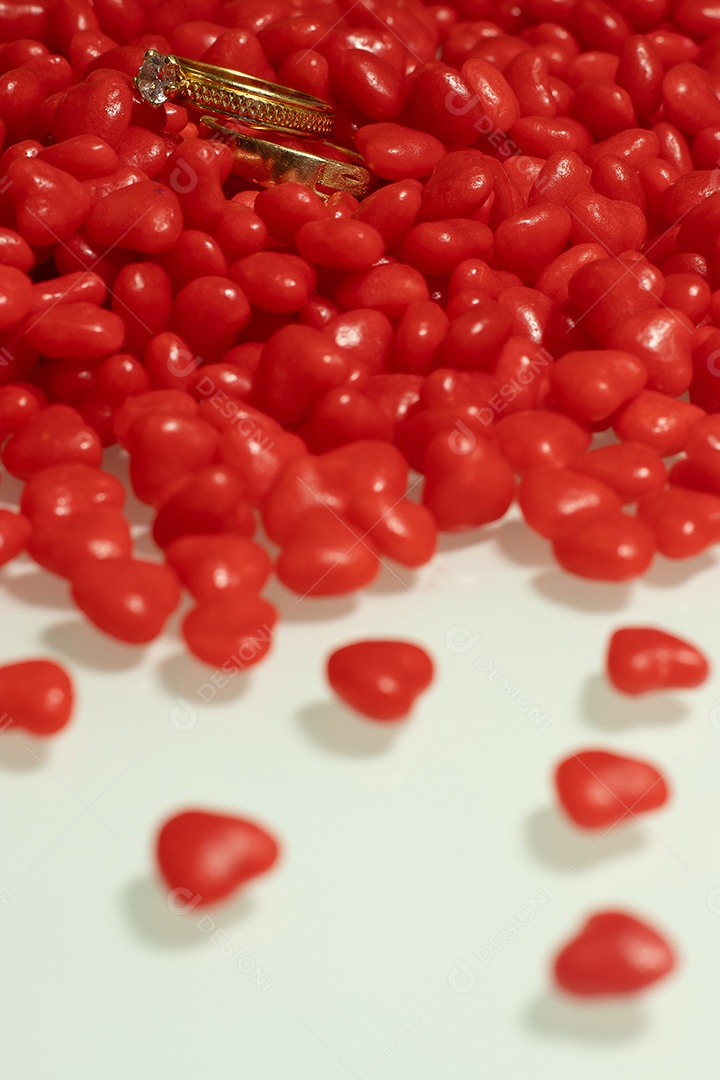 Um anel com vários corações pequenos na mesa branca