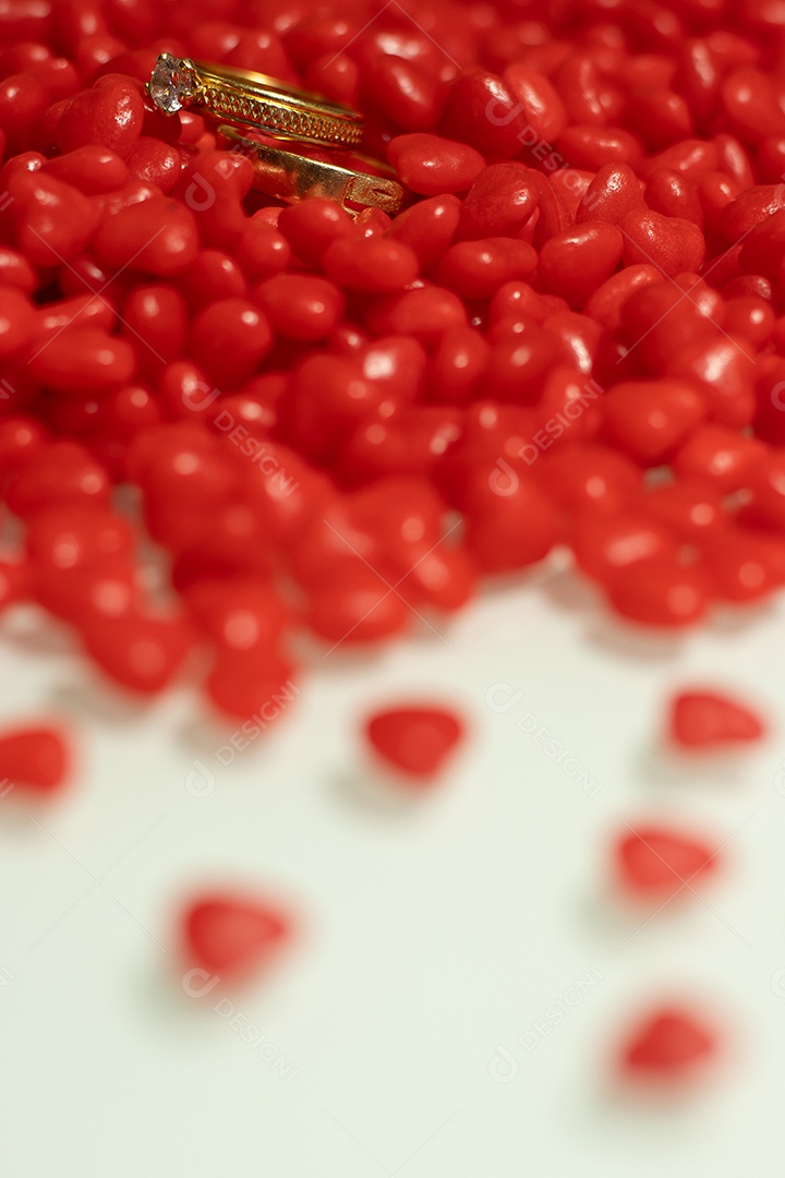 Um anel com vários corações pequenos na mesa branca