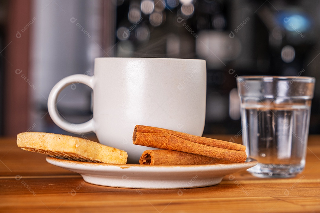 Uma xícara de café expresso um copo pequeno de água com gás e biscoitos