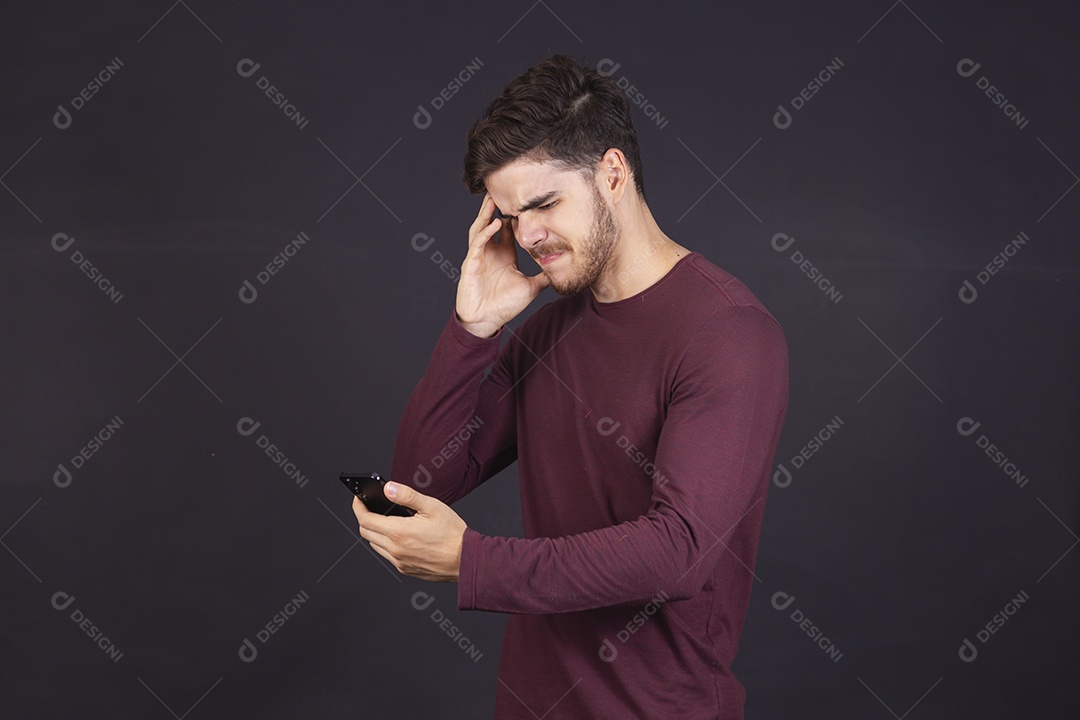 Homem jovem sobre fundo isolado mexendo no seu celular