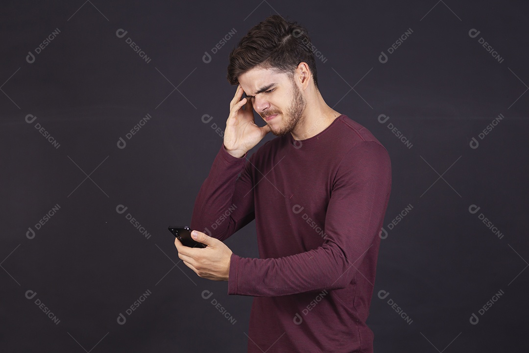 Homem jovem sobre fundo isolado mexendo no seu celular