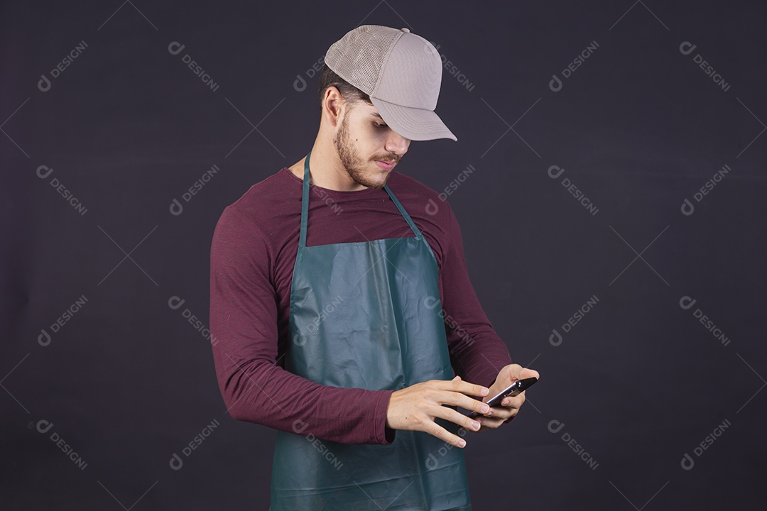 Homem jovem sobre fundo isolado mexendo no seu celular