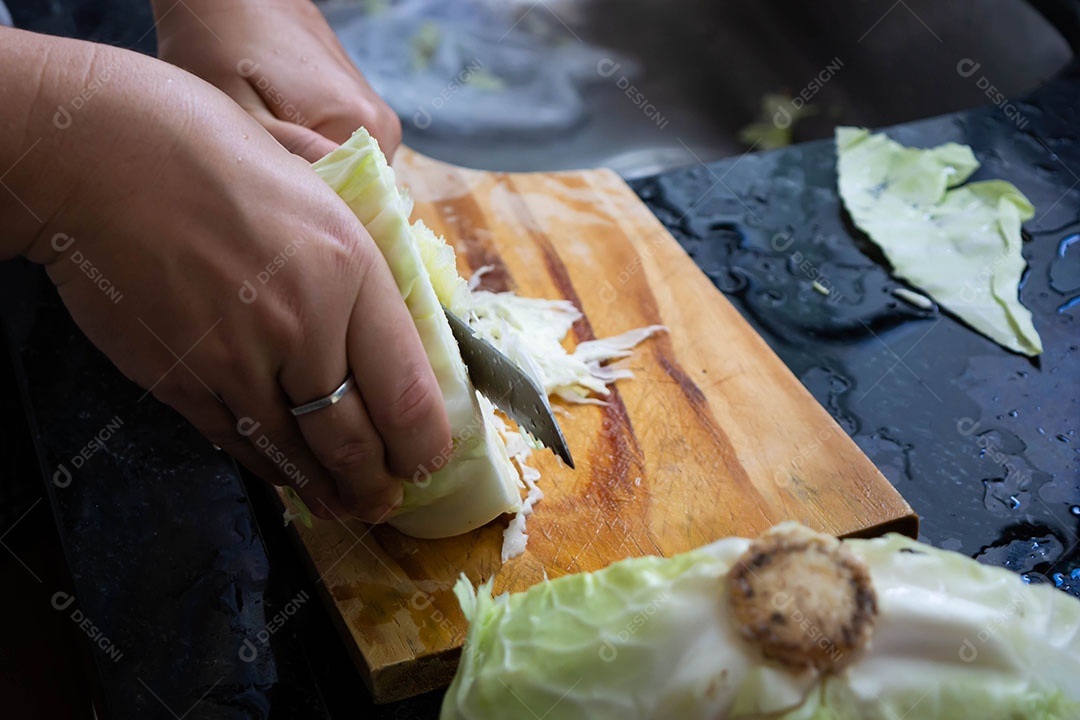Mulher cortando repolho na cozinha