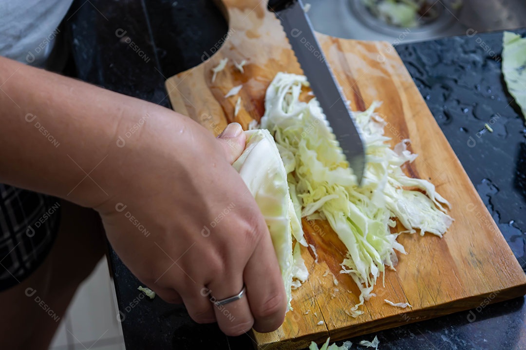 Mulher cortando repolho na cozinha