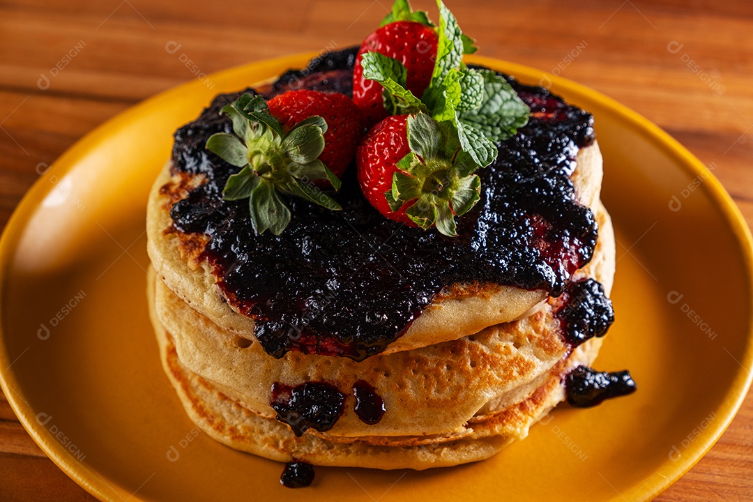 Panquecas recheadas com frutas e cobertas com geléia de frutas vermelhas