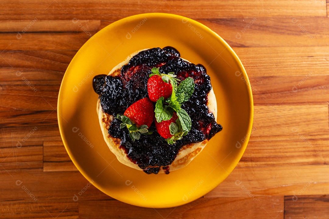 Panquecas recheadas com frutas e cobertas com geléia de frutas vermelhas