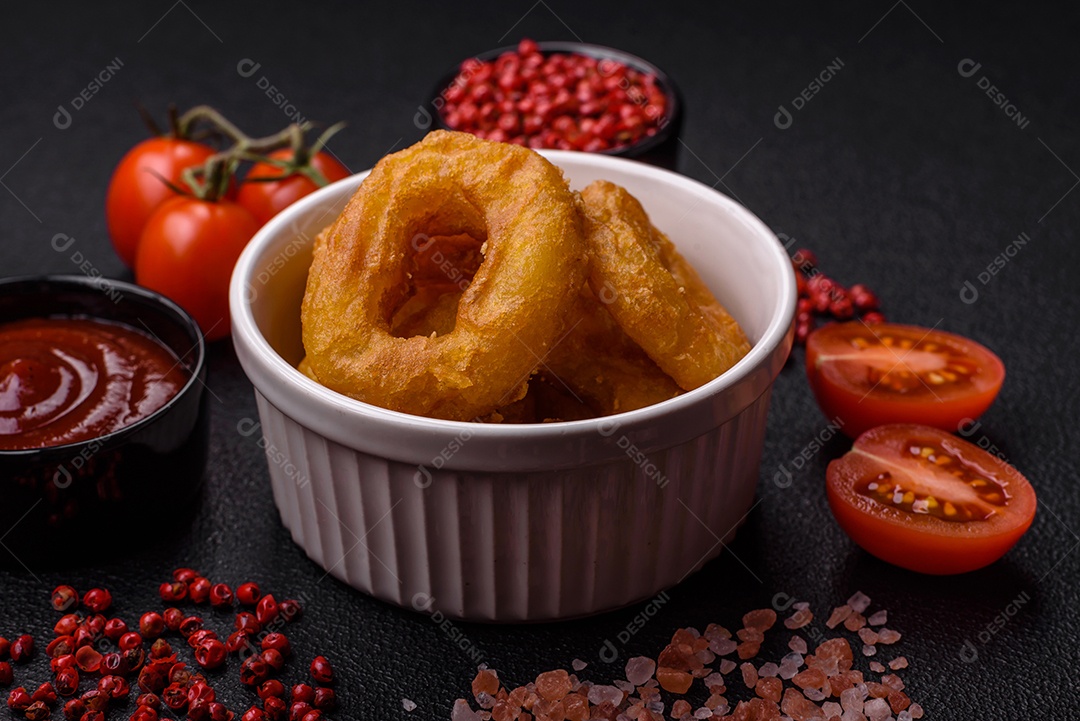Deliciosas lulas nutritivas ou anéis de cebola fritos com sal e especiarias sobre um fundo escuro de concreto