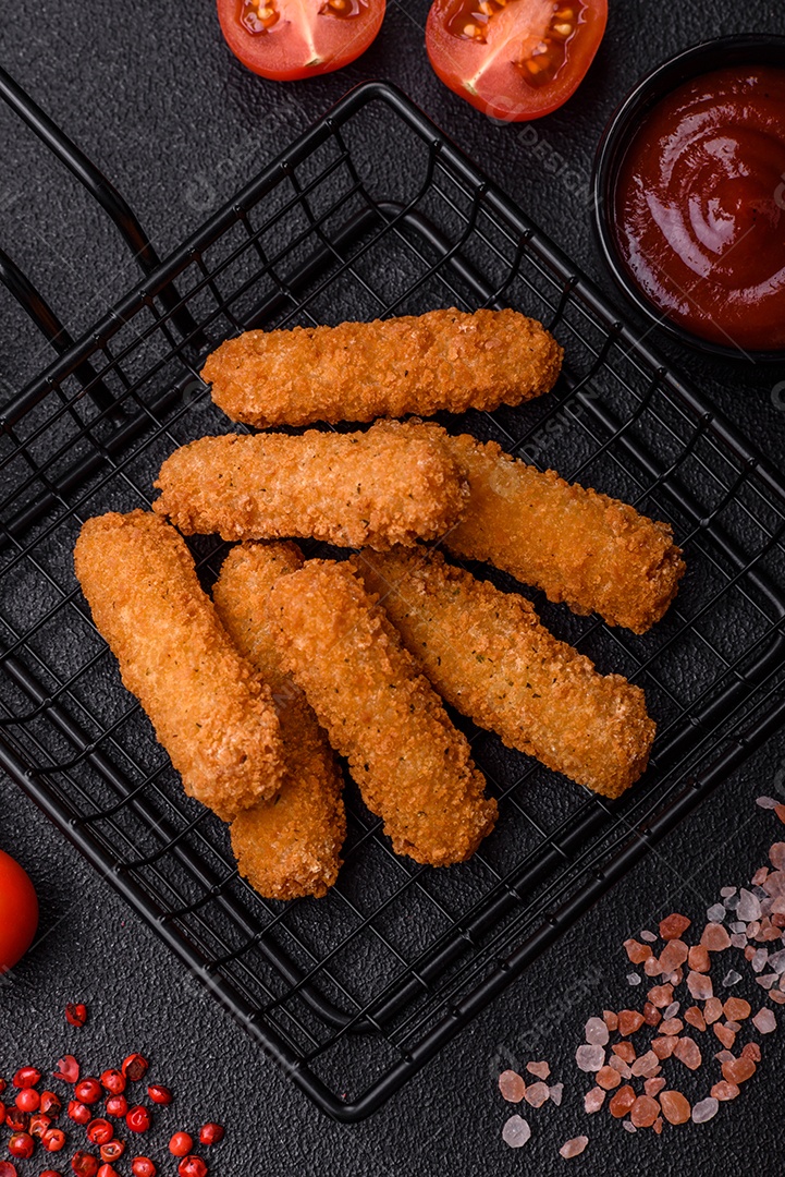 Deliciosas lulas nutritivas ou anéis de cebola fritos com sal e especiarias sobre um fundo escuro de concreto