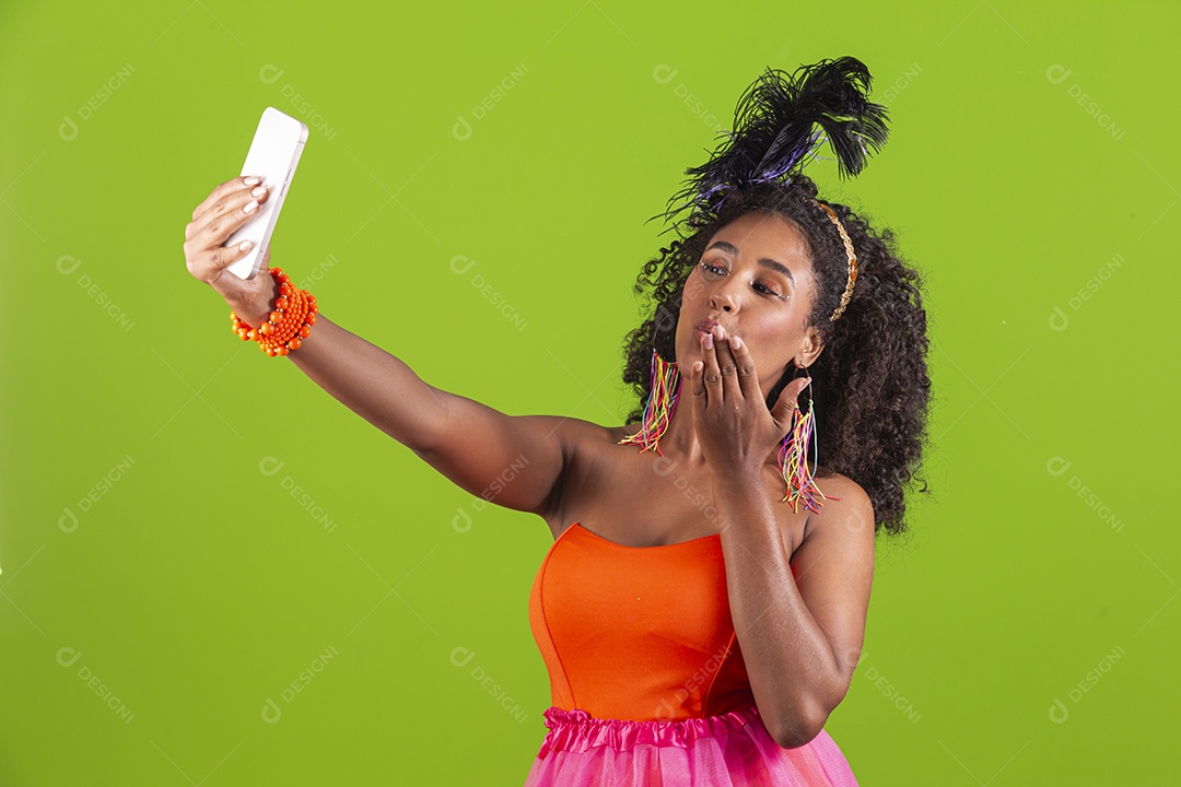 Linda mulher jovem celebrando carnaval segurando celular smartphone