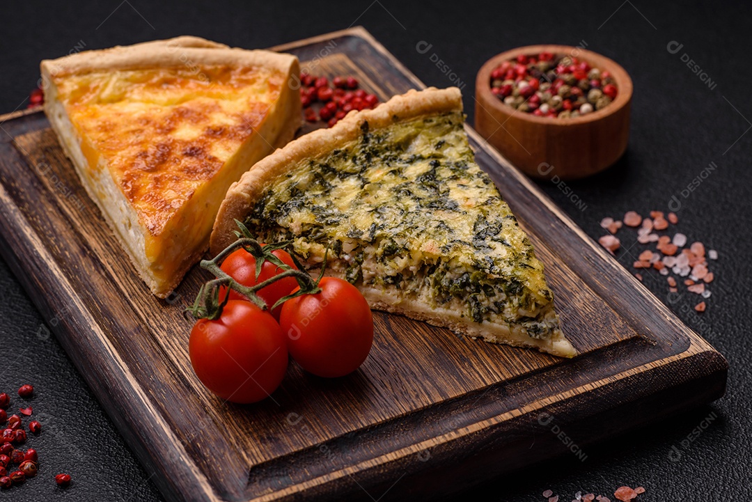 Deliciosa quiche crocante cortada em fatias com queijo, brócolis, tomate, sal, especiarias e ervas sobre um fundo escuro de concreto