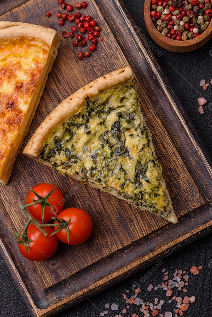 Deliciosa quiche crocante cortada em fatias com queijo, brócolis, tomate, sal, especiarias e ervas sobre um fundo escuro de concreto