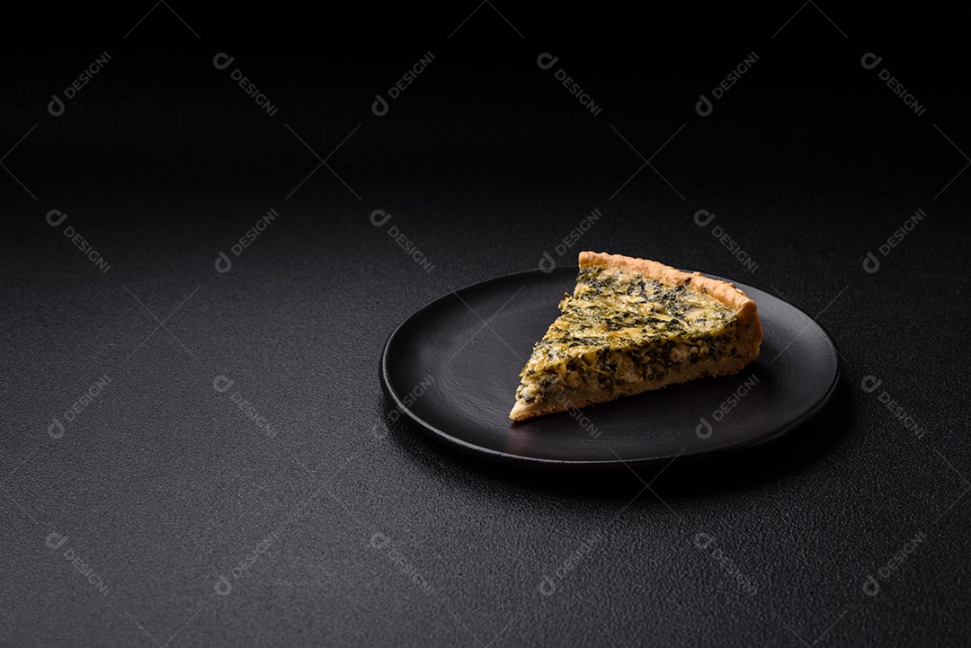 Deliciosa quiche crocante cortada em fatias com queijo, brócolis, tomate, sal, especiarias e ervas sobre um fundo escuro de concreto