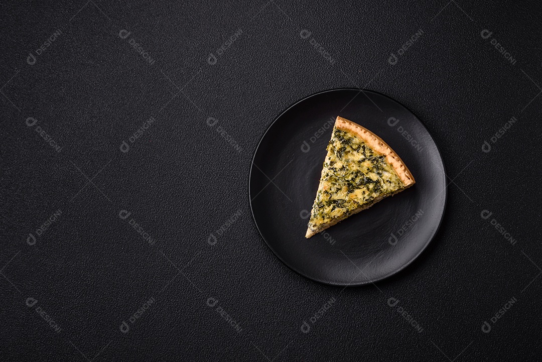 Deliciosa quiche crocante cortada em fatias com queijo, brócolis, tomate, sal, especiarias e ervas sobre um fundo escuro de concreto