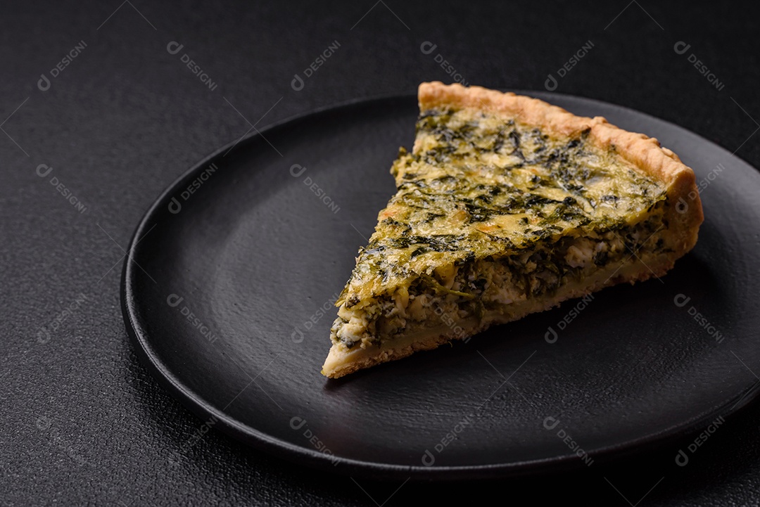 Deliciosa quiche crocante cortada em fatias com queijo, brócolis, tomate, sal, especiarias e ervas sobre um fundo escuro de concreto