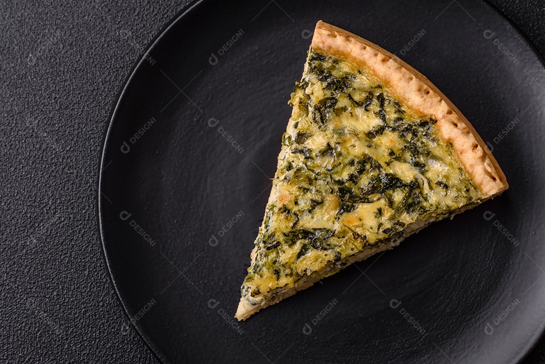 Deliciosa quiche crocante cortada em fatias com queijo, brócolis, tomate, sal, especiarias e ervas sobre um fundo escuro de concreto