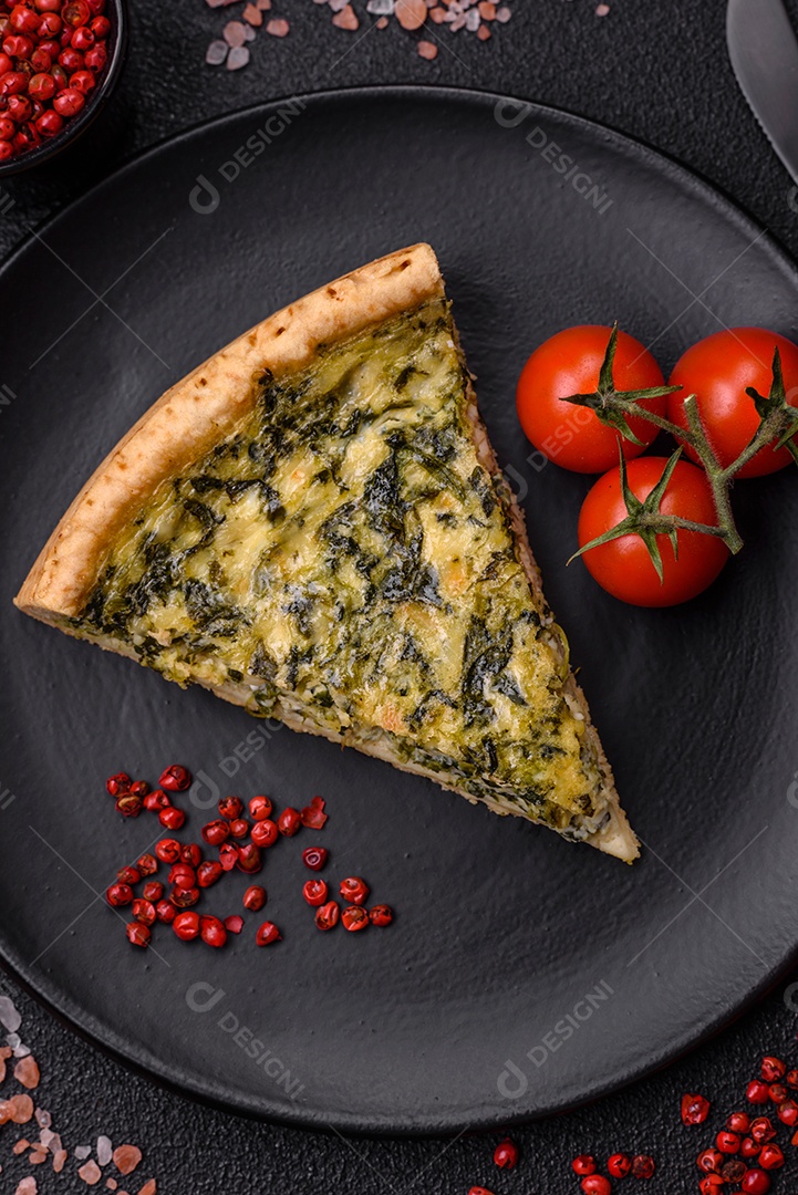 Deliciosa quiche crocante cortada em fatias com queijo, brócolis, tomate, sal, especiarias e ervas sobre um fundo escuro de concreto