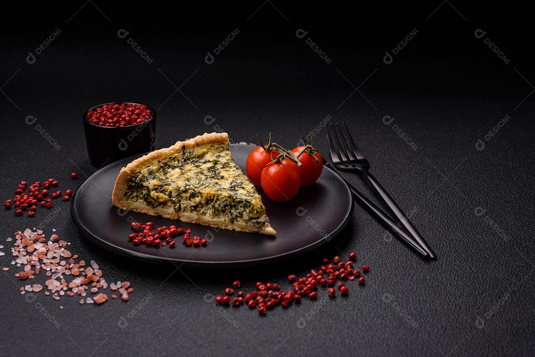 Deliciosa quiche crocante cortada em fatias com queijo, brócolis, tomate, sal, especiarias e ervas sobre um fundo escuro de concreto