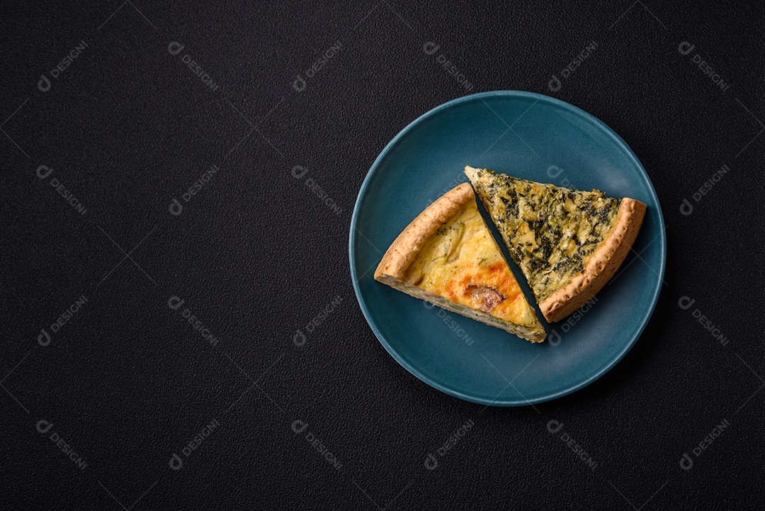 Deliciosa quiche crocante cortada em fatias com queijo, brócolis, tomate, sal, especiarias e ervas sobre um fundo escuro de concreto