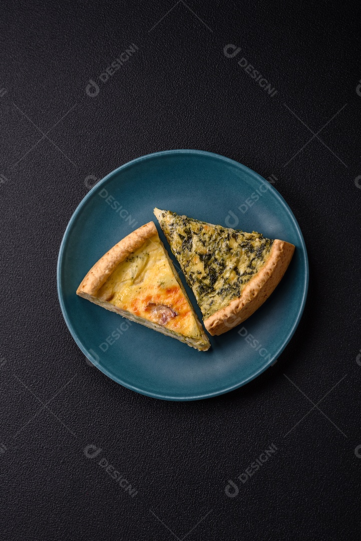 Deliciosa quiche crocante cortada em fatias com queijo, brócolis, tomate, sal, especiarias e ervas sobre um fundo escuro de concreto