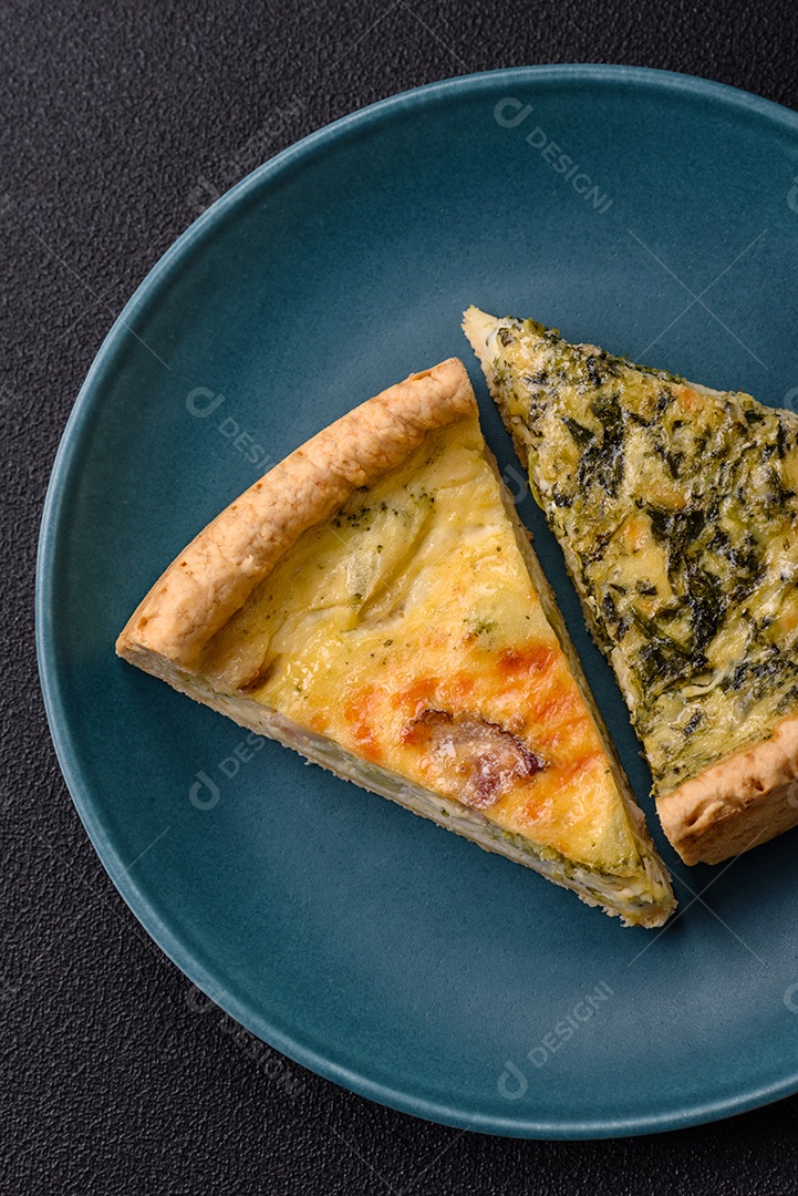 Deliciosa quiche crocante cortada em fatias com queijo, brócolis, tomate, sal, especiarias e ervas sobre um fundo escuro de concreto