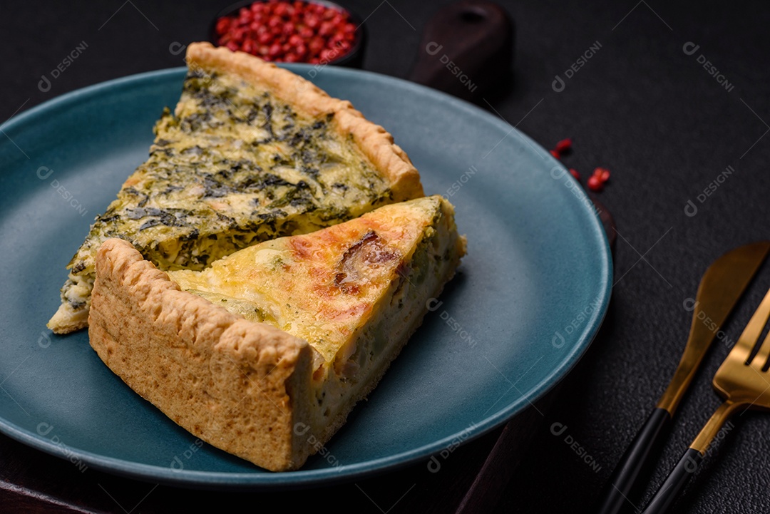 Deliciosa quiche crocante cortada em fatias com queijo, brócolis, tomate, sal, especiarias e ervas sobre um fundo escuro de concreto
