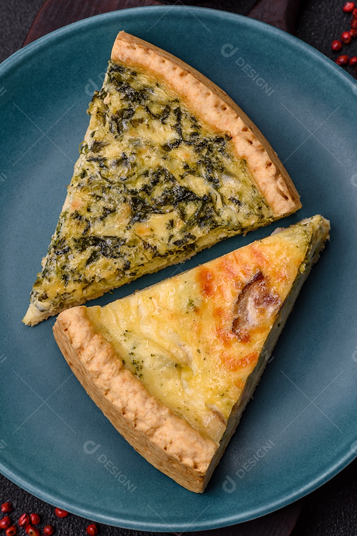 Deliciosa quiche crocante cortada em fatias com queijo, brócolis, tomate, sal, especiarias e ervas sobre um fundo escuro de concreto