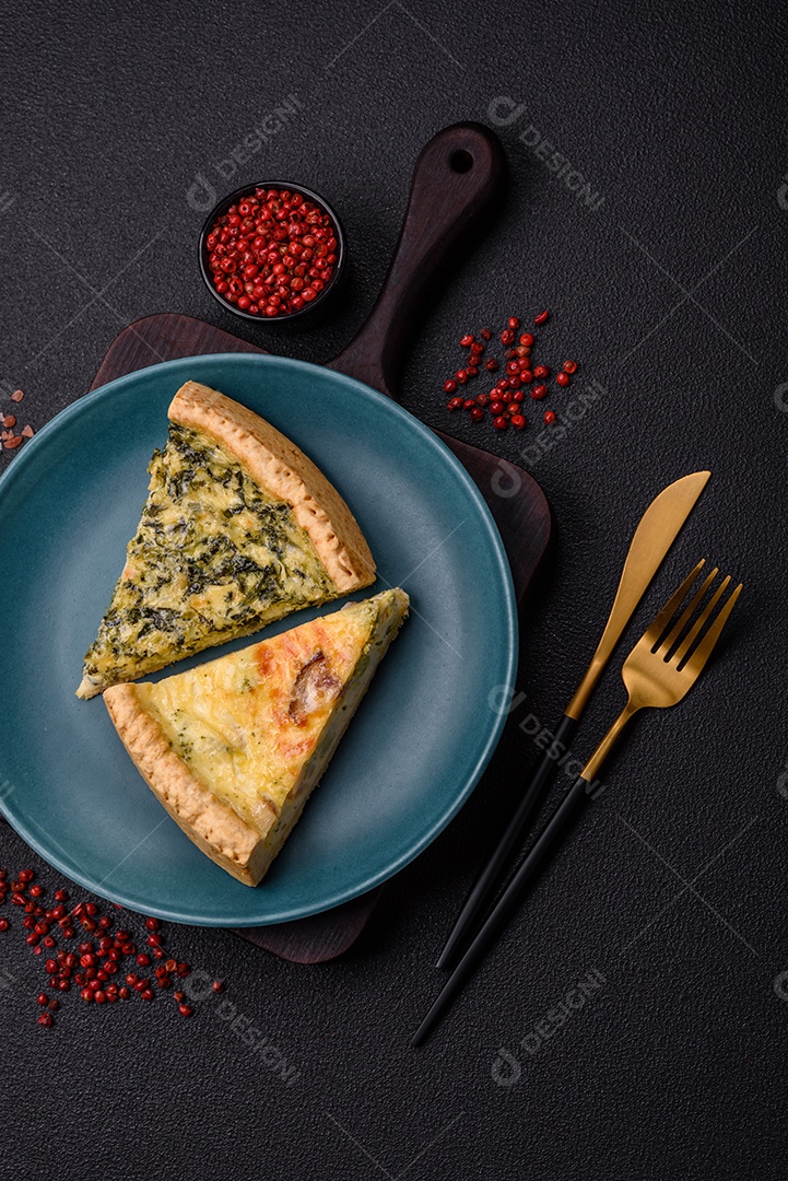 Deliciosa quiche crocante cortada em fatias com queijo, brócolis, tomate, sal, especiarias e ervas sobre um fundo escuro de concreto