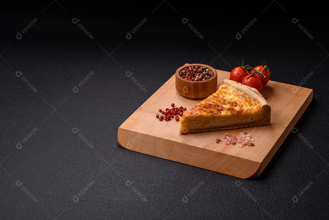Deliciosa quiche crocante cortada em fatias com queijo, brócolis, tomate, sal, especiarias e ervas sobre um fundo escuro de concreto