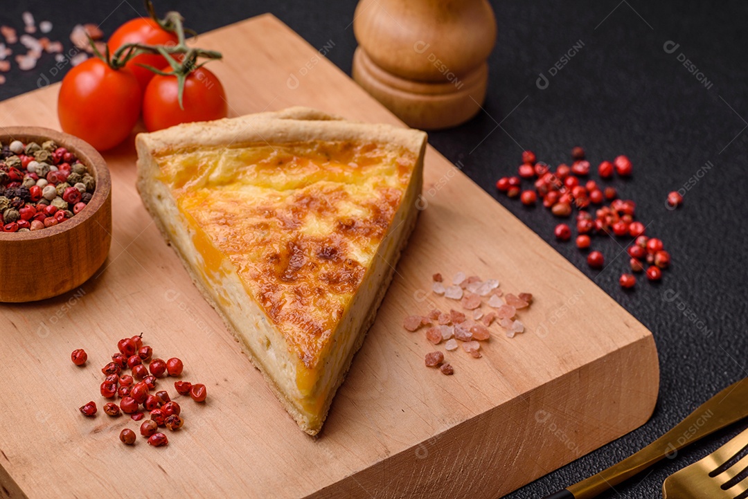 Deliciosa quiche crocante cortada em fatias com queijo, brócolis, tomate, sal, especiarias e ervas sobre um fundo escuro de concreto