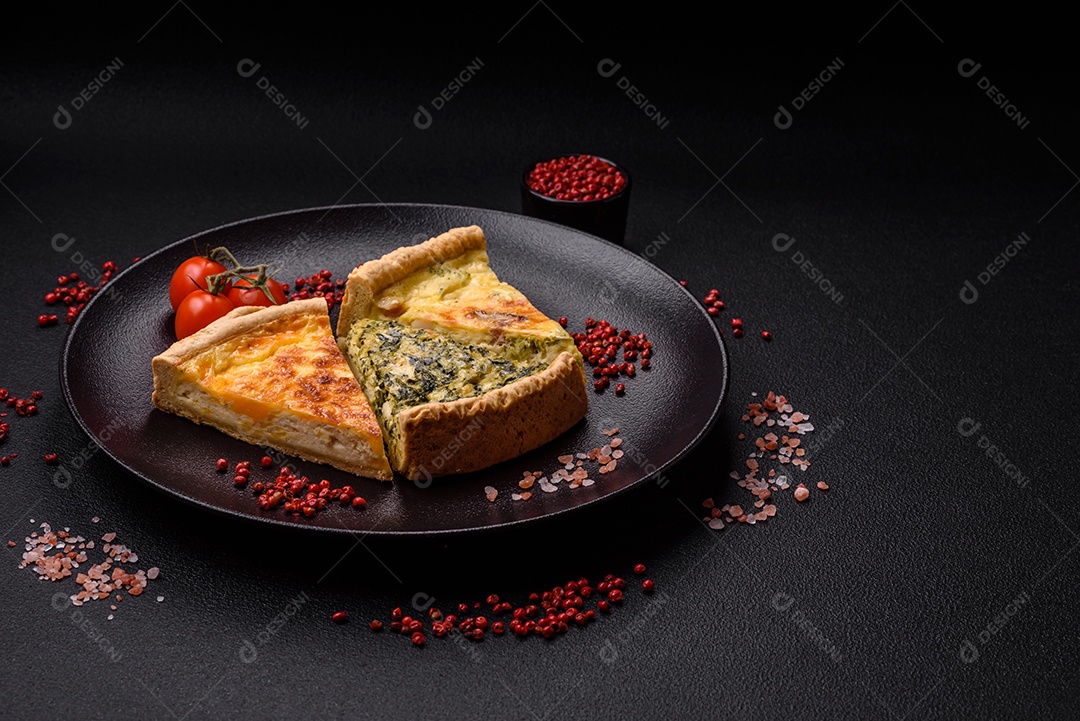 Deliciosa quiche crocante cortada em fatias com queijo, brócolis, tomate, sal, especiarias e ervas sobre um fundo escuro de concreto