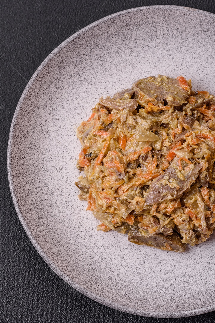 Deliciosa língua de carne cozida ou de porco cortada com cenouras, cebolas, creme de leite e especiarias num prato cerâmico