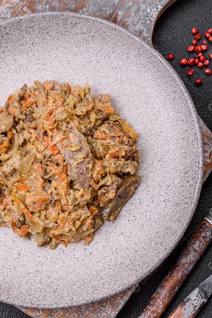 Deliciosa língua de carne cozida ou de porco cortada com cenouras, cebolas, creme de leite e especiarias num prato cerâmico