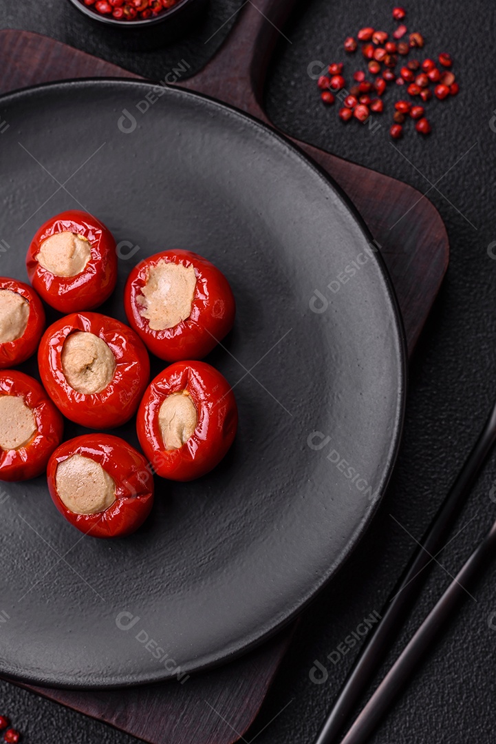 Pimentões vermelhos recheados com queijo ou carne com sal, especiarias e ervas num prato de cerâmica