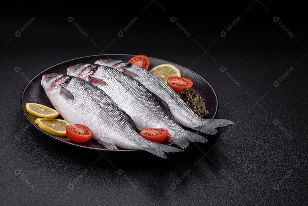 Peixe fresco de robalo oceânico cru com sal, especiarias e ervas em fundo de concreto escuro