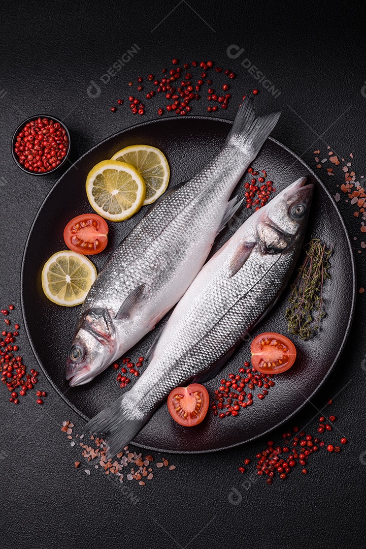 Peixe fresco de robalo oceânico cru com sal, especiarias e ervas em fundo de concreto escuro