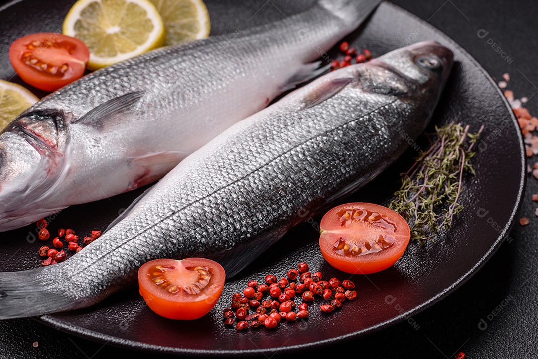 Peixe fresco de robalo oceânico cru com sal, especiarias e ervas em fundo de concreto escuro